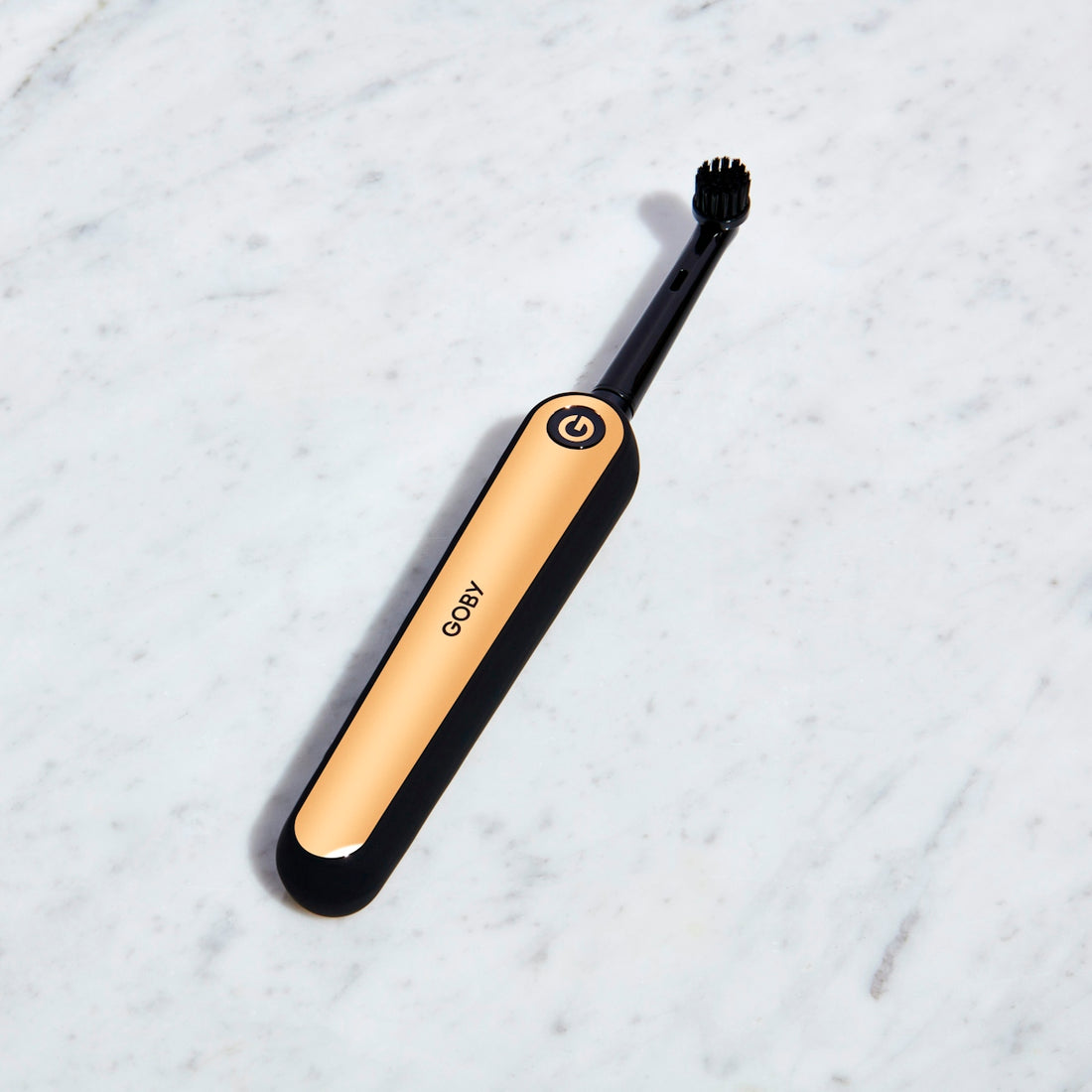 black and gold Goby electric toothbrush on white surface