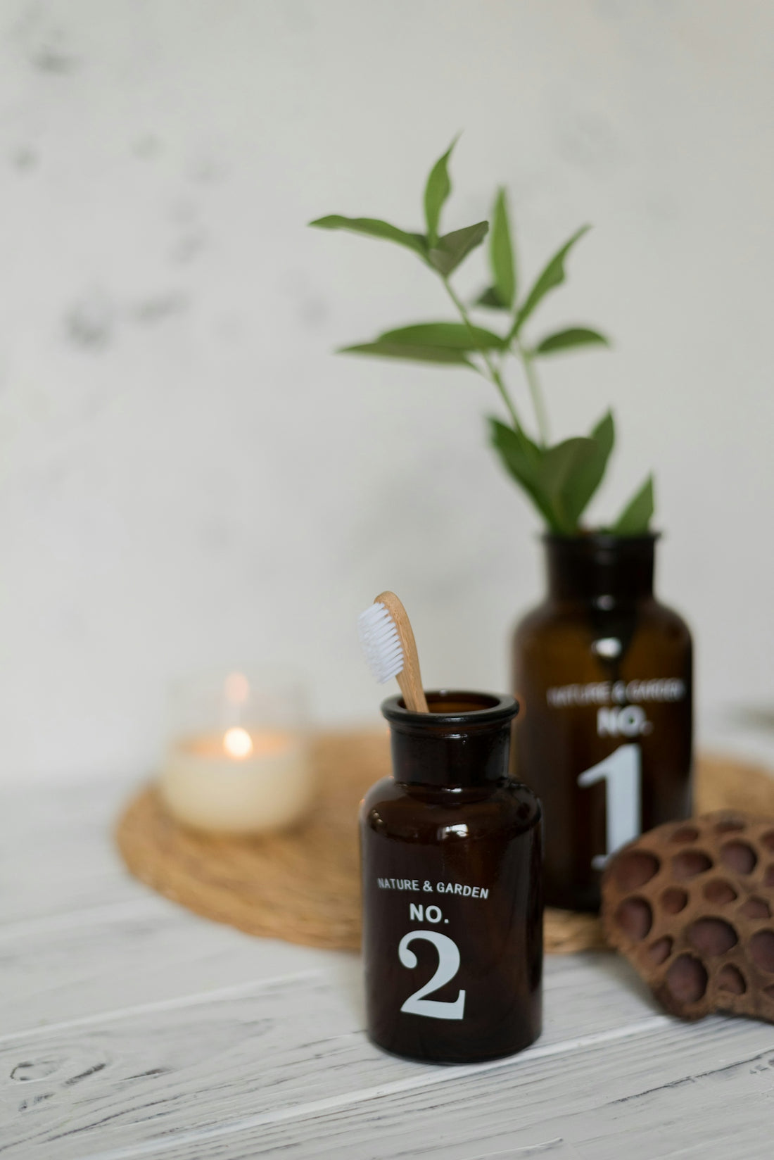 a plant in a jar next to a candle and a jar of chocolate spread