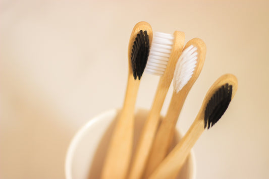 four toothbrushes in a cup on a table