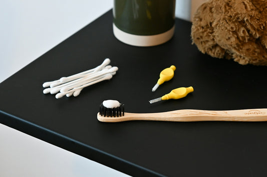 a toothbrush, toothpaste, and a teddy bear on a table