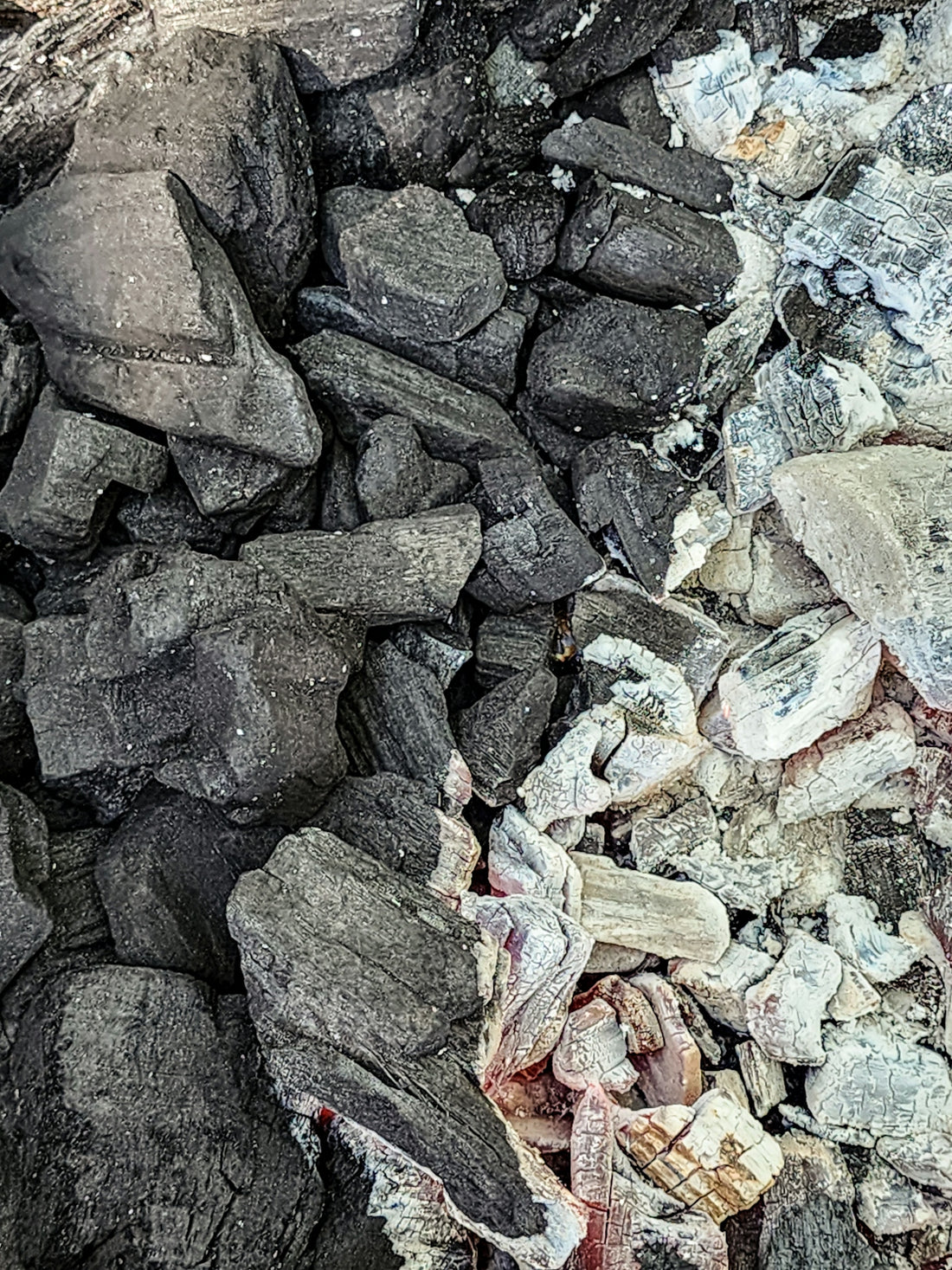 Charcoal briquettes with varying stages of burning.